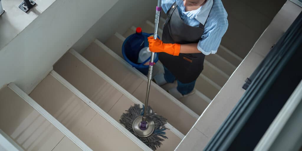 Femme de ménage en train de nettoyer des marches d’escalier
