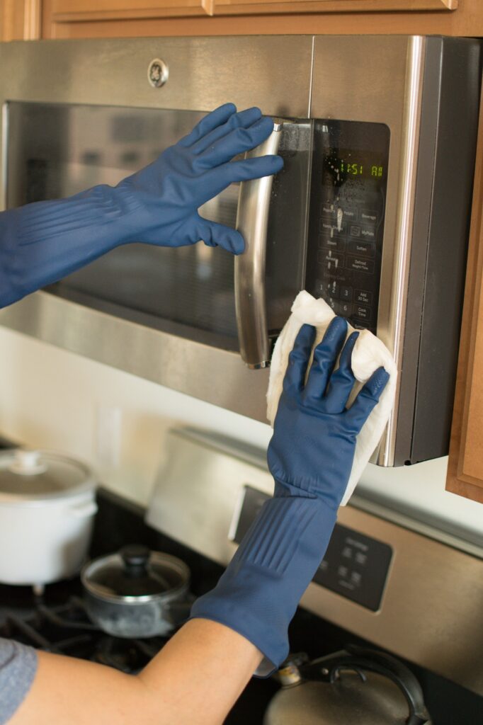 Cleaning the microwave in the kitchen.