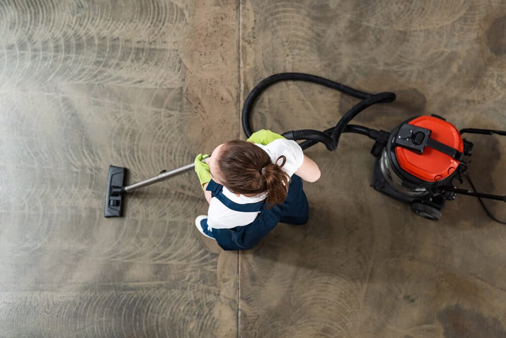 Femme qui passe l’aspirateur sur un sol très sale