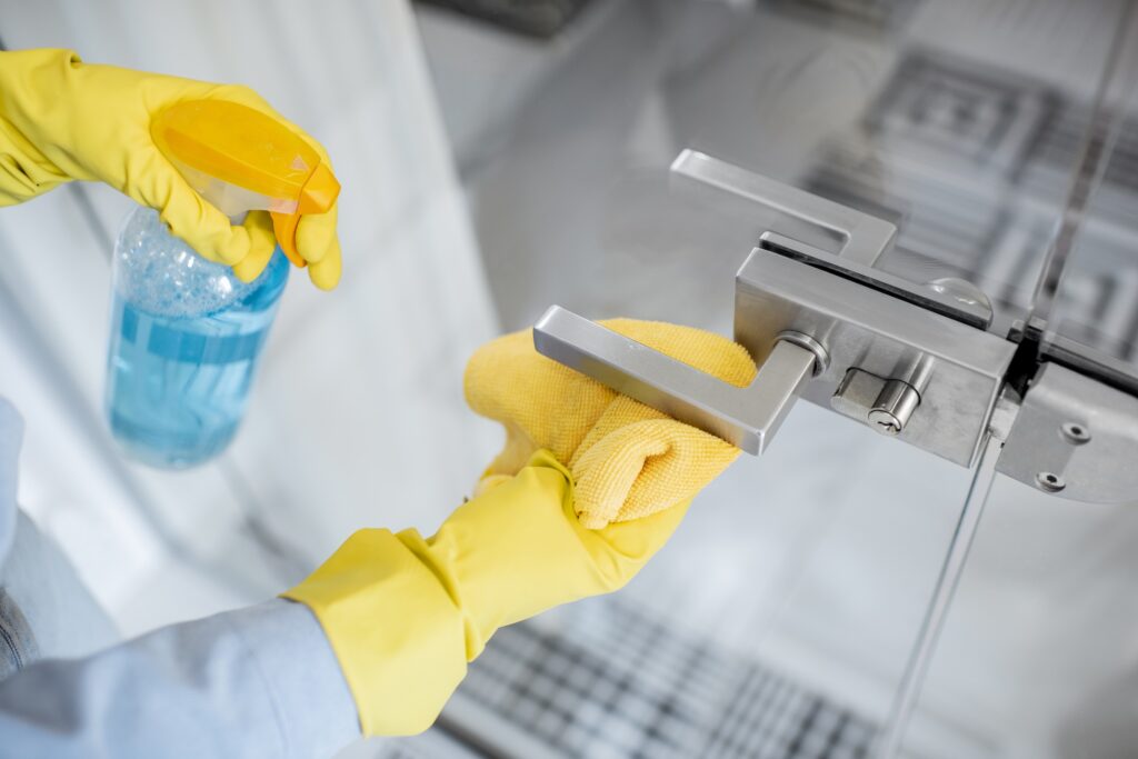 Woman cleaning door handle at home
